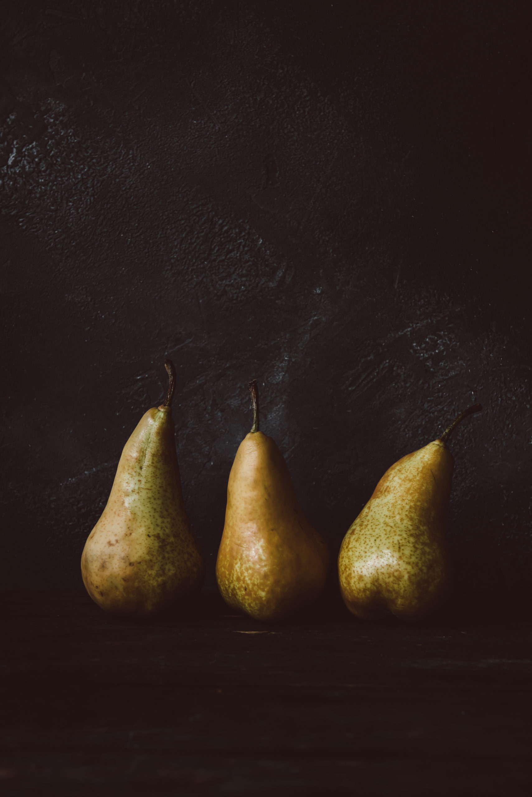 three pears on a dark background