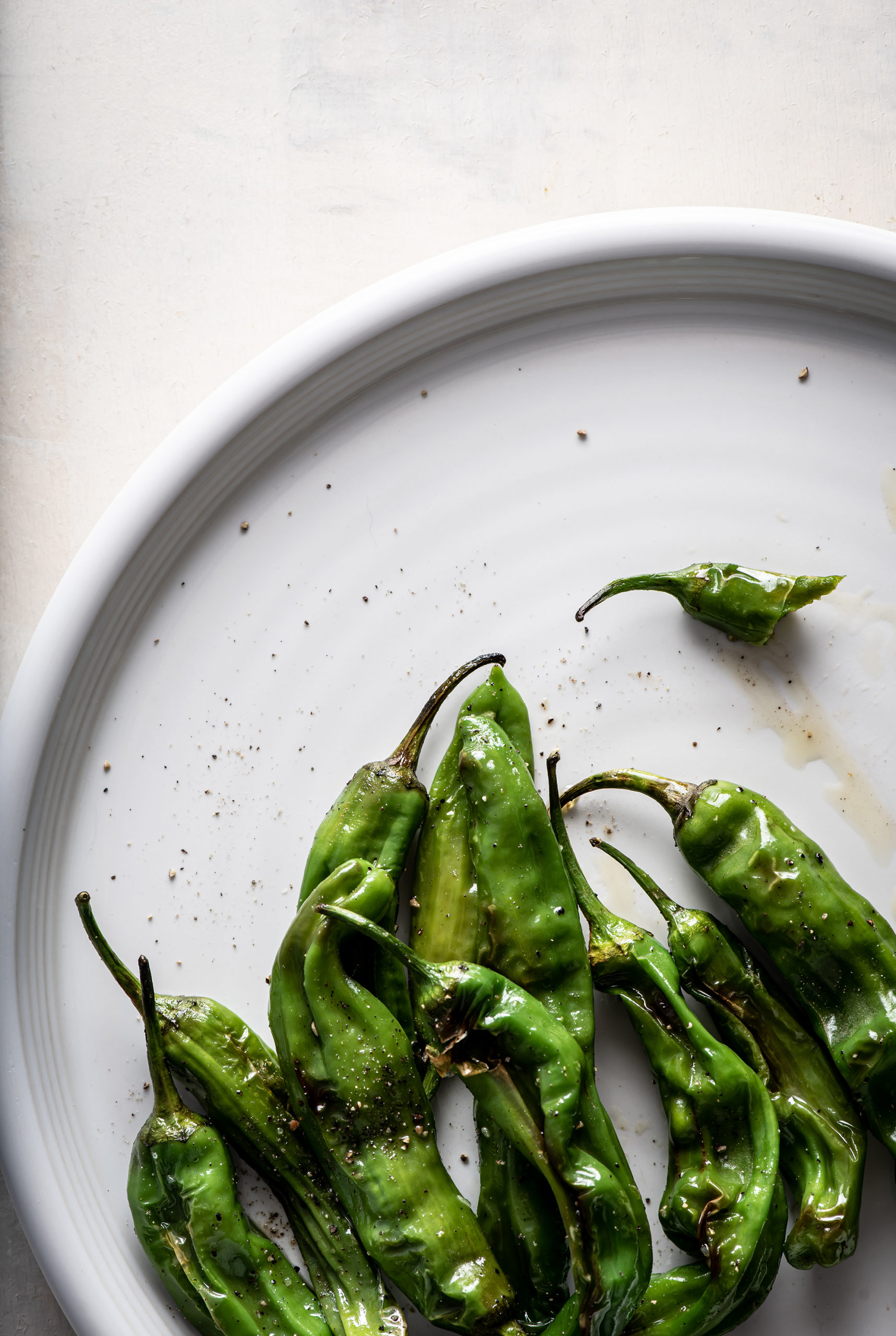 Shishito peppers on a white plate