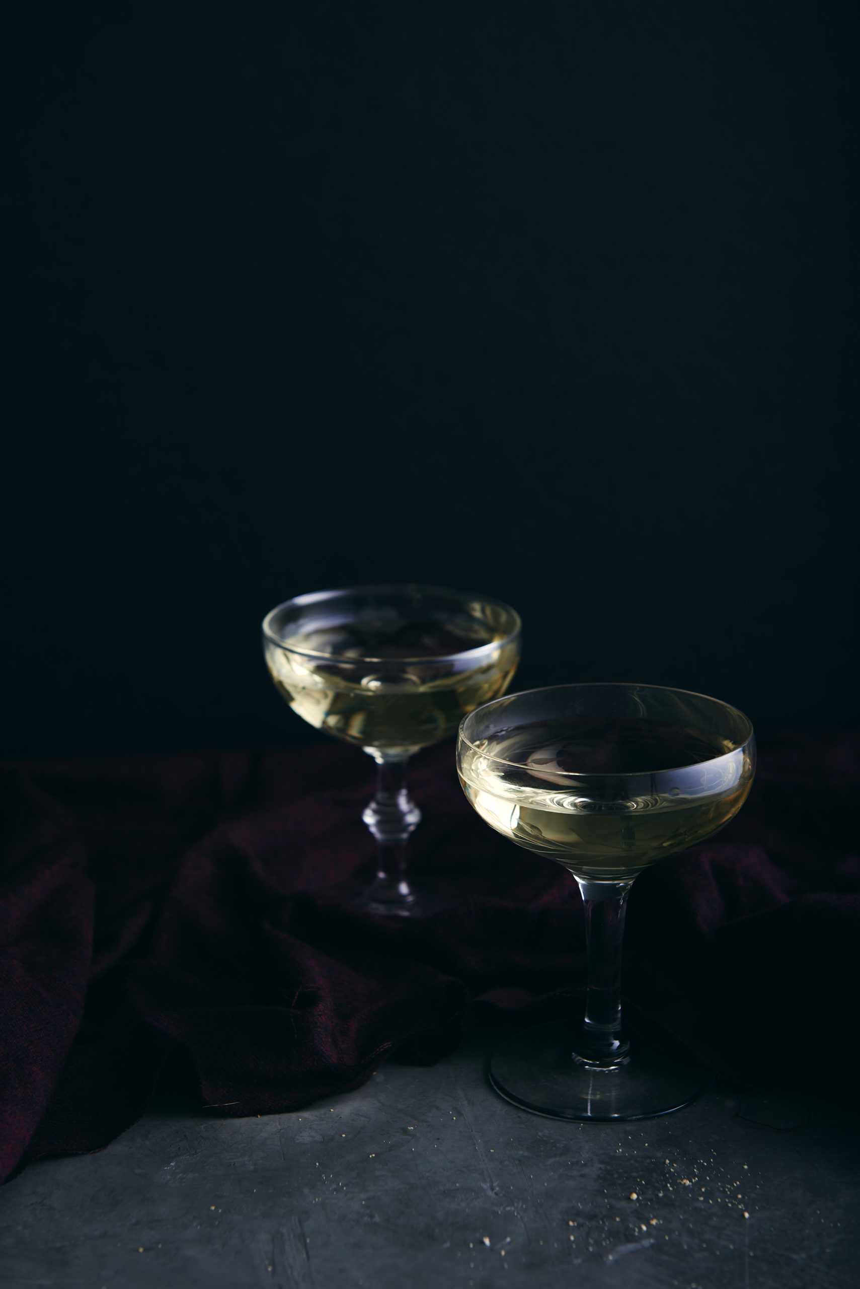 two wine glasses with a dark background