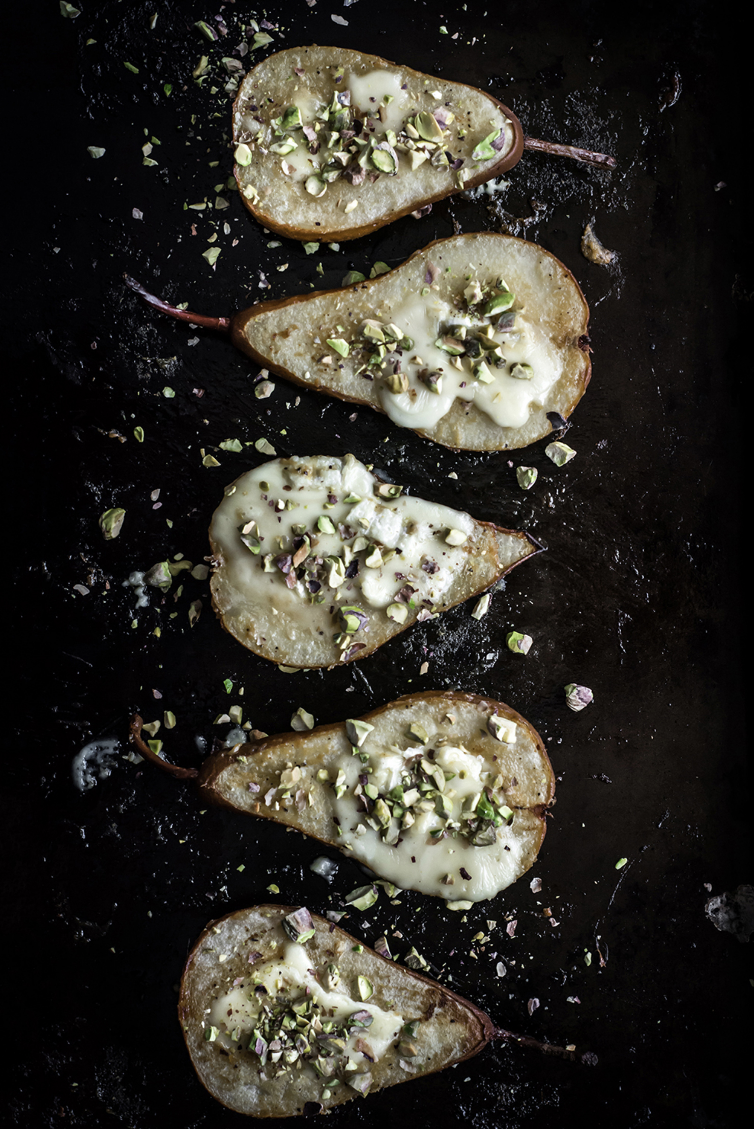 pears lined up on dark surface