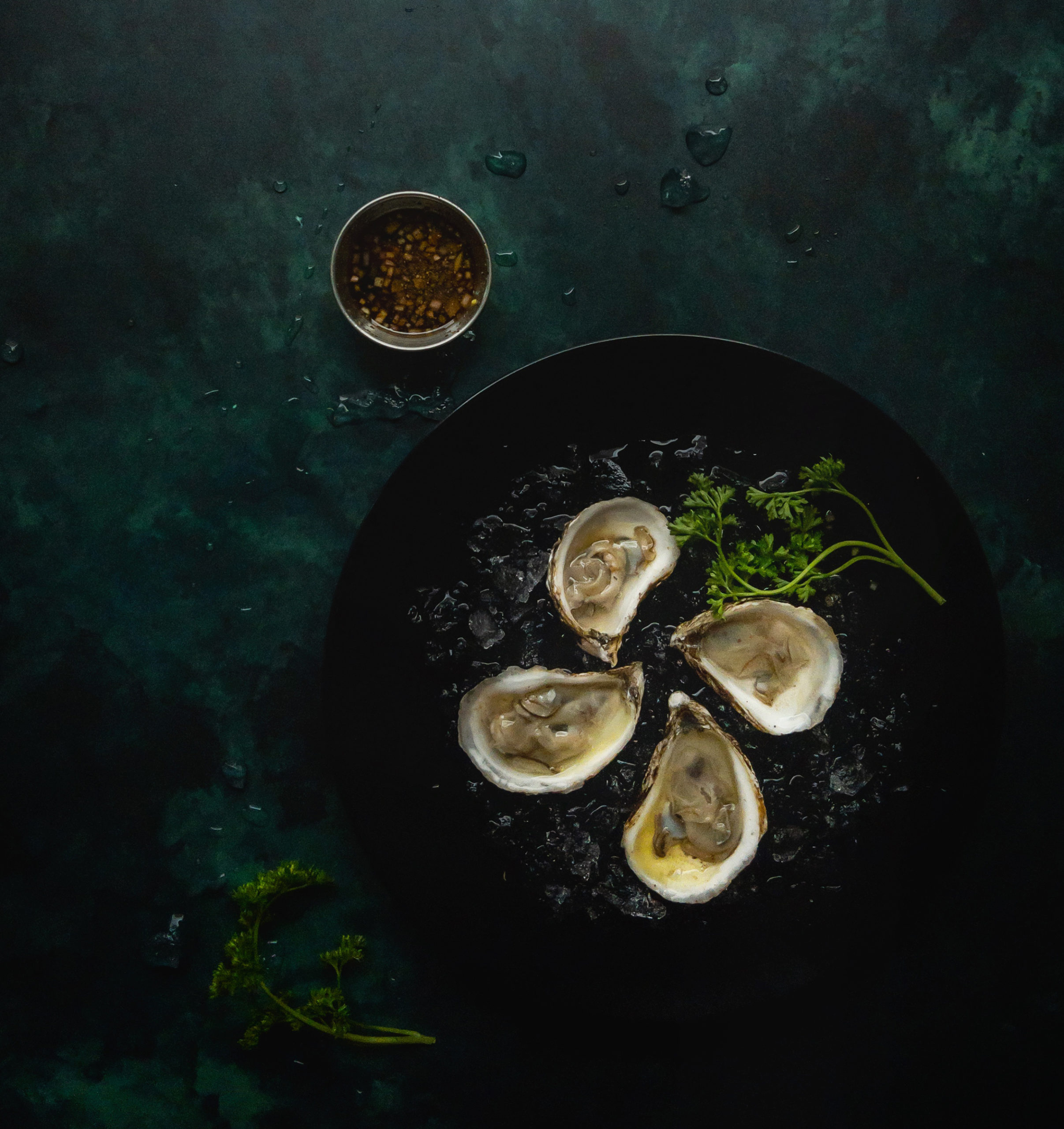 oysters on a dark plate on a green background